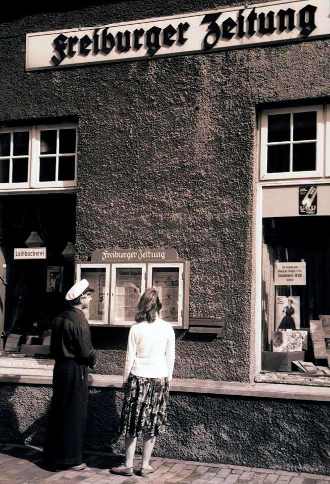 Personen vor dem Schaukasten der aktuellen Ausgabe der "Freiburger Zeitung" Aufnahme von ca. 1955